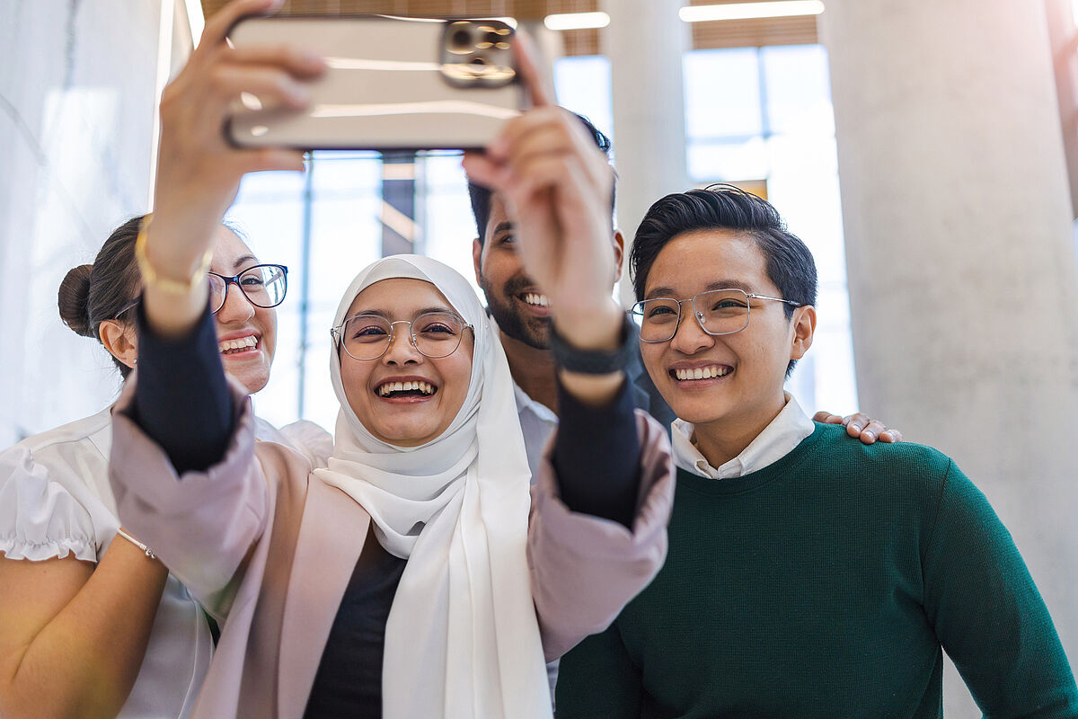 Introduction_Image_Symbolbild_IM_Master_SL_2023 Introduction_Image Studiengang IM Master Drei International Students nehmen ein Selfie auf